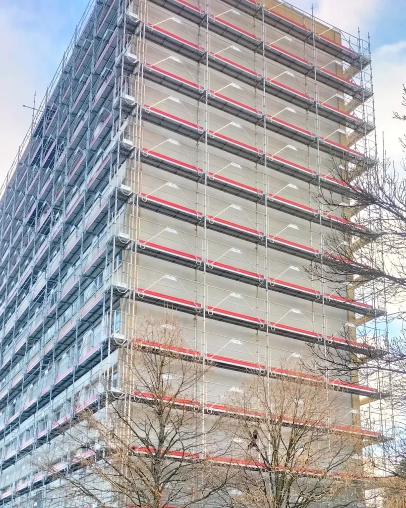 Échafaudage multidirectionnel monté à l'angle d'un immeuble de grande hauteur, structure filante sur toute la façade