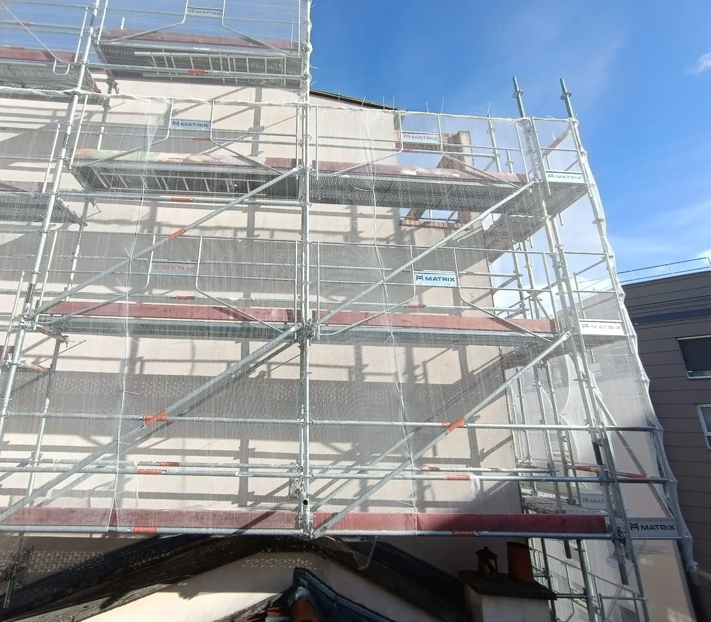 Structure d'échafaudage de toiture au-dessus d'une couverture en tuiles à Paris 10e